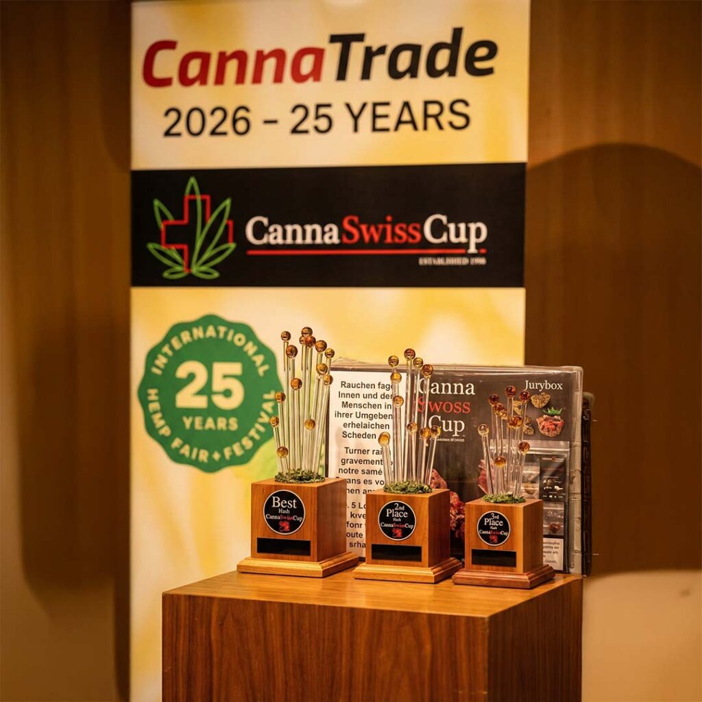 CannaSwissCup 2026 Trophäen vor der Jurybox mit dem gesetzlich vorgeschriebenen gelben Warnhinweis: CBD kann müde machen.