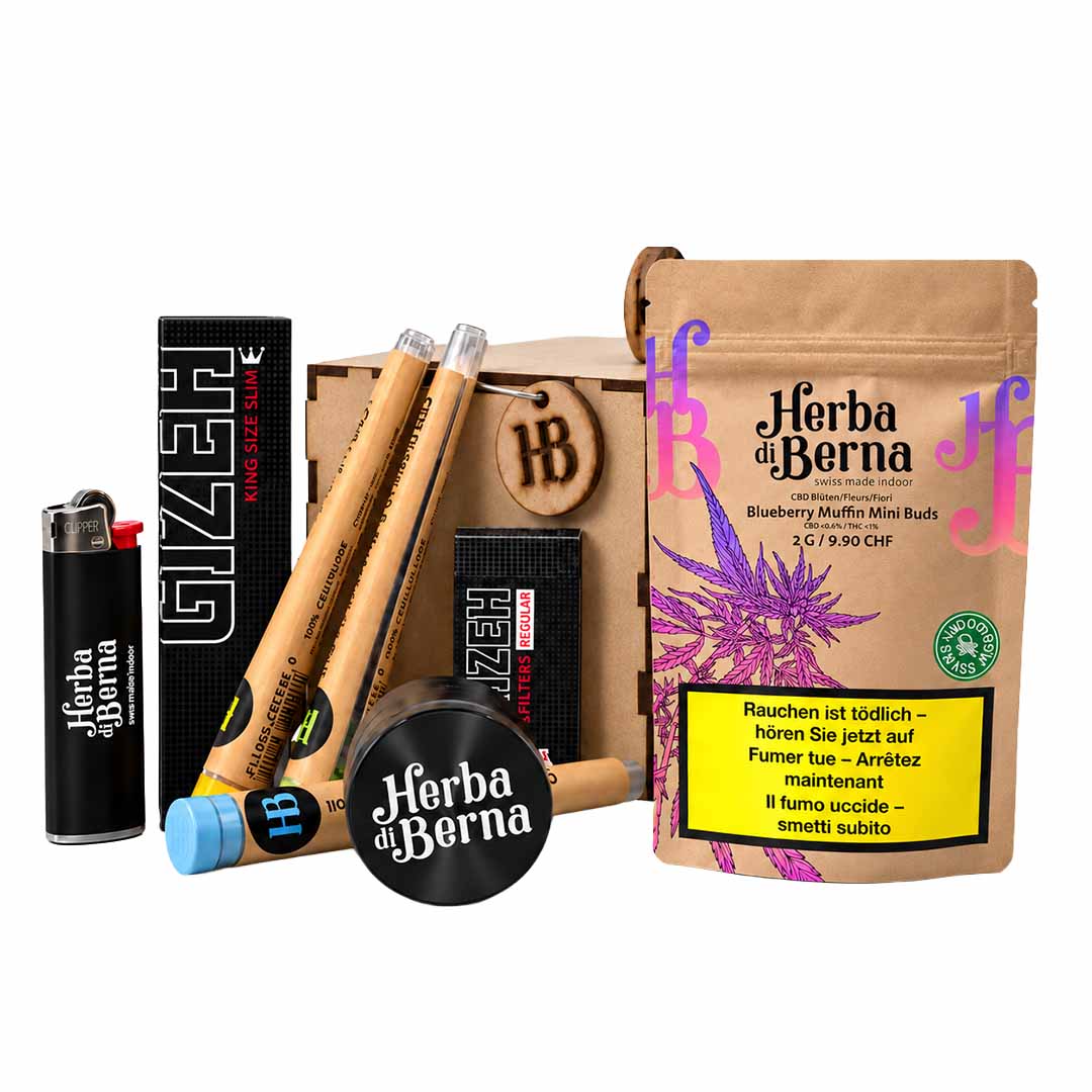 Boîte « Smoker Box » de Herba di Berna contenant 2 g de mini-bourgeons « Blueberry Muffin », ainsi que des joints pré-roulés, un broyeur, un briquet et une boîte en bois pressé