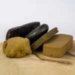 Verschiedene Arten von CBD Hasch in der Schweiz, darunter gepresstes Cannabisharz, Kief und traditionelle Haschformen auf Holzuntergrund.
